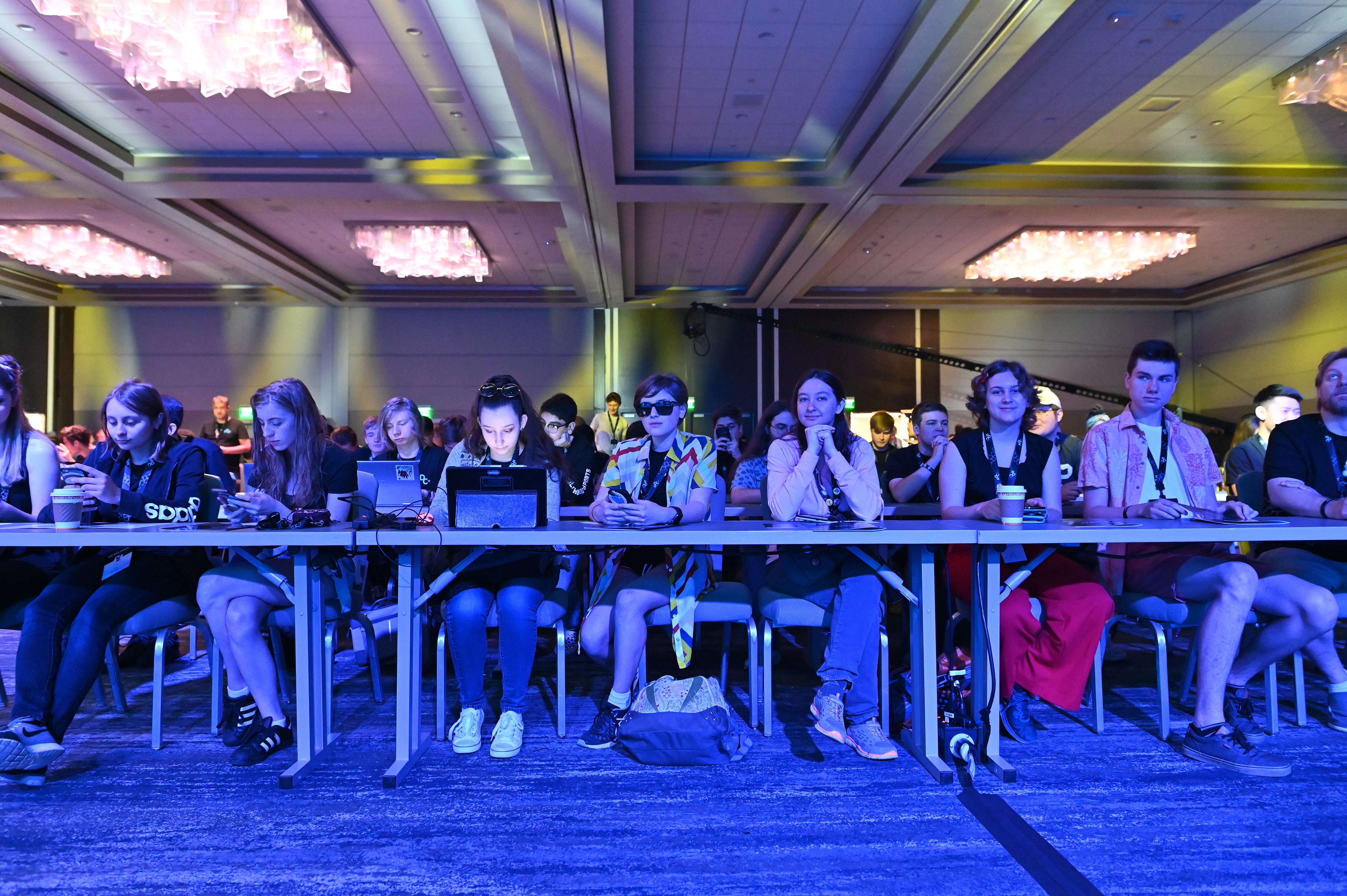 Panel of participants seated at a long table during a tech conference event
