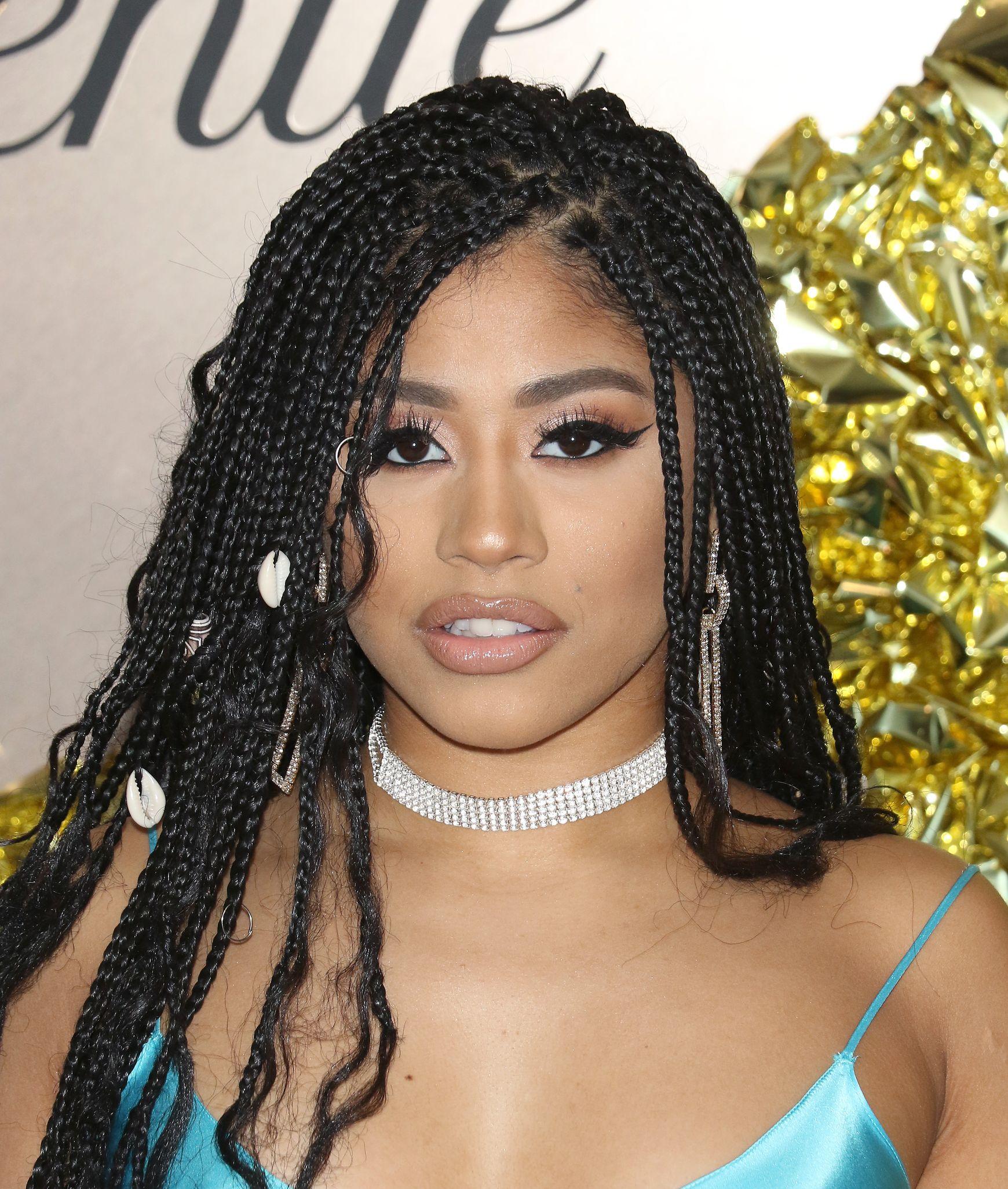 Hennessy Carolina wearing a blue top and diamond choker at an event