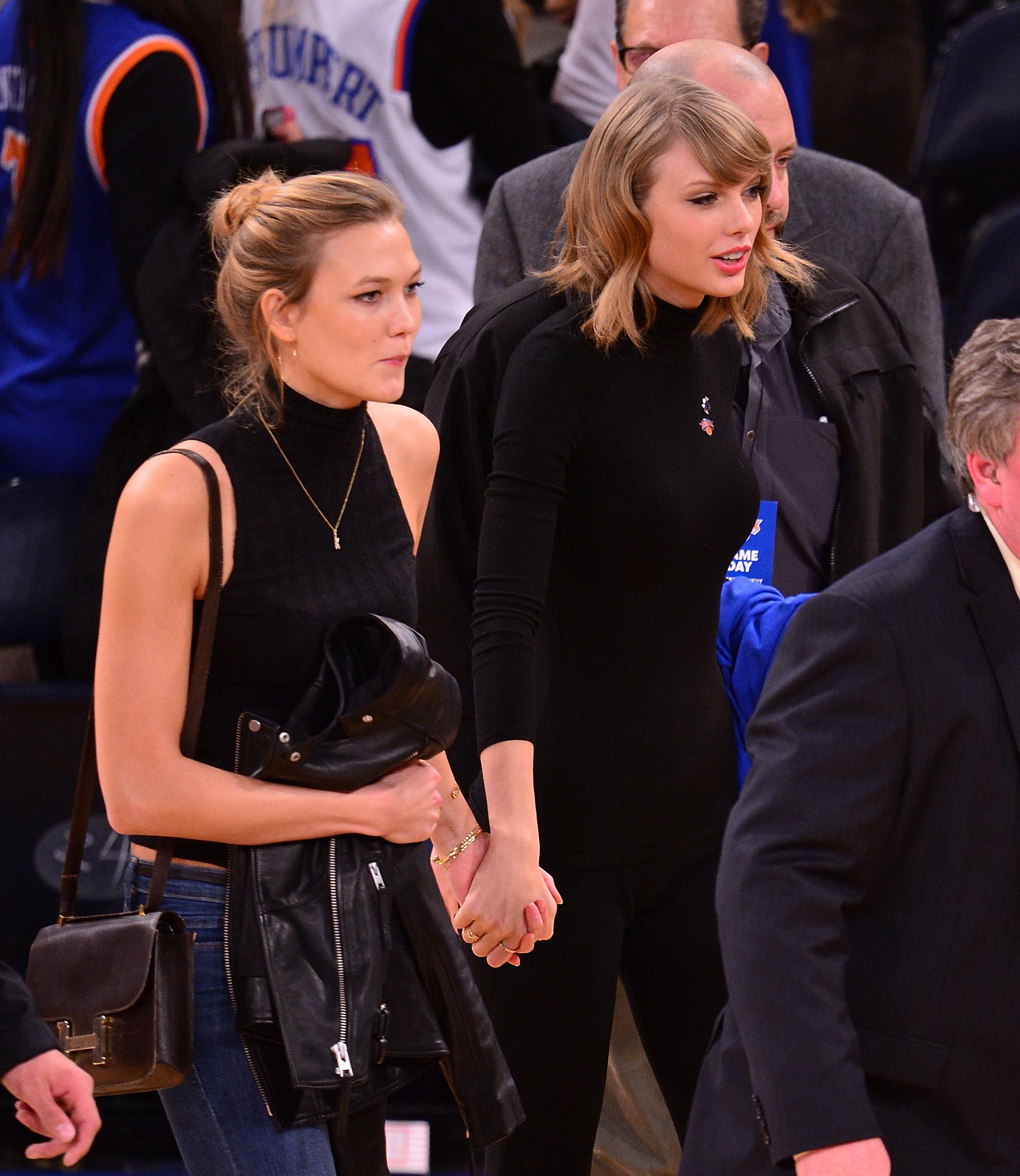 Two women in black attire at a basketball game courtside