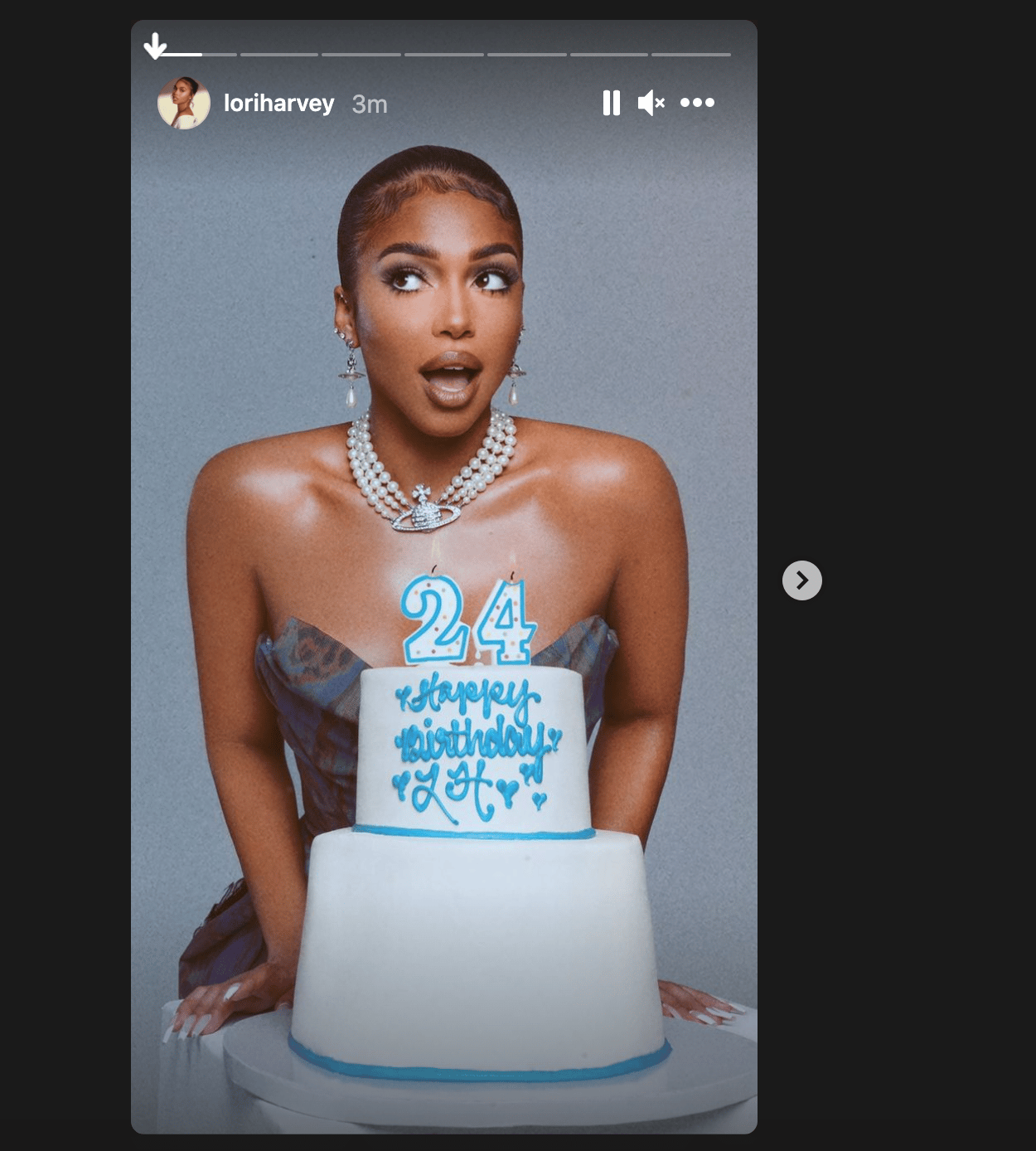 Lori Harvey poses with a two-tier birthday cake decorated with "24" and "Happy Birthday Lori