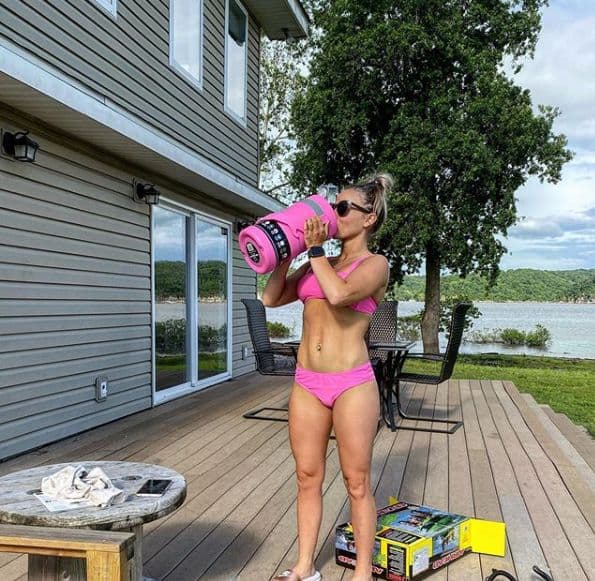 Mackenzie McKee doing a handstand exercise on a deck overlooking a lake