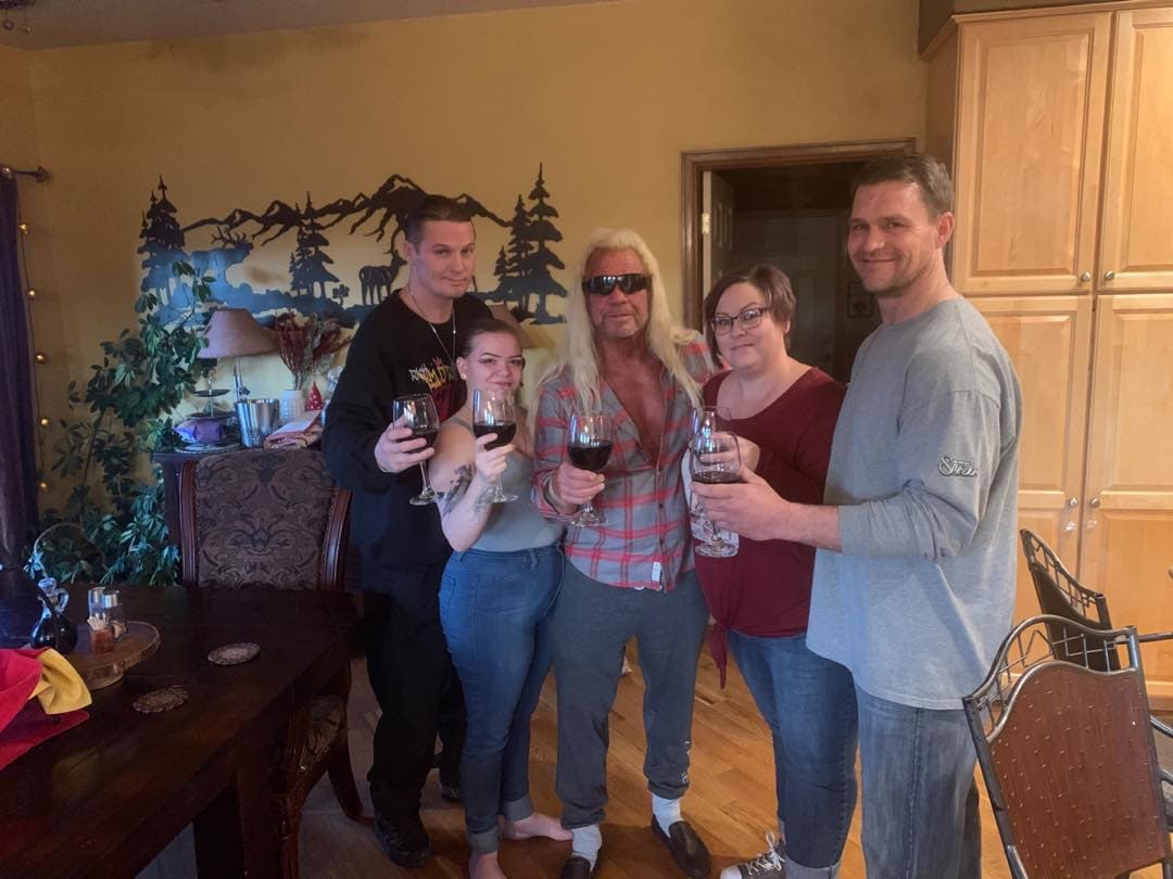 Dog the Bounty Hunter and family members toasting with drinks at a holiday gathering