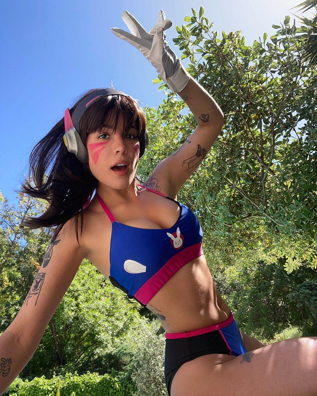 Person in gaming-inspired outfit with headphones and face paint posing outdoors